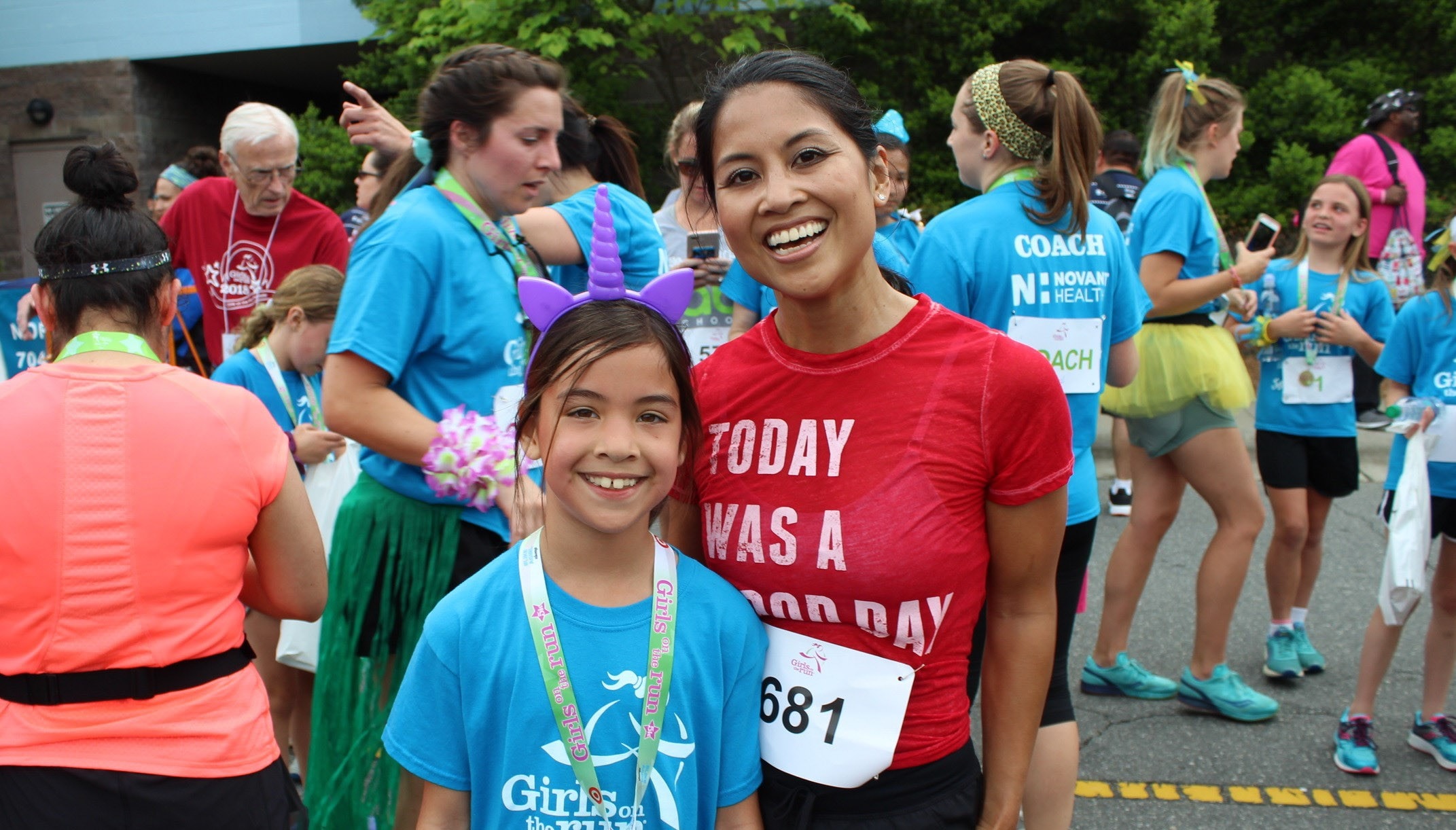 Girls on the run participant smiles with running buddy at 5K
